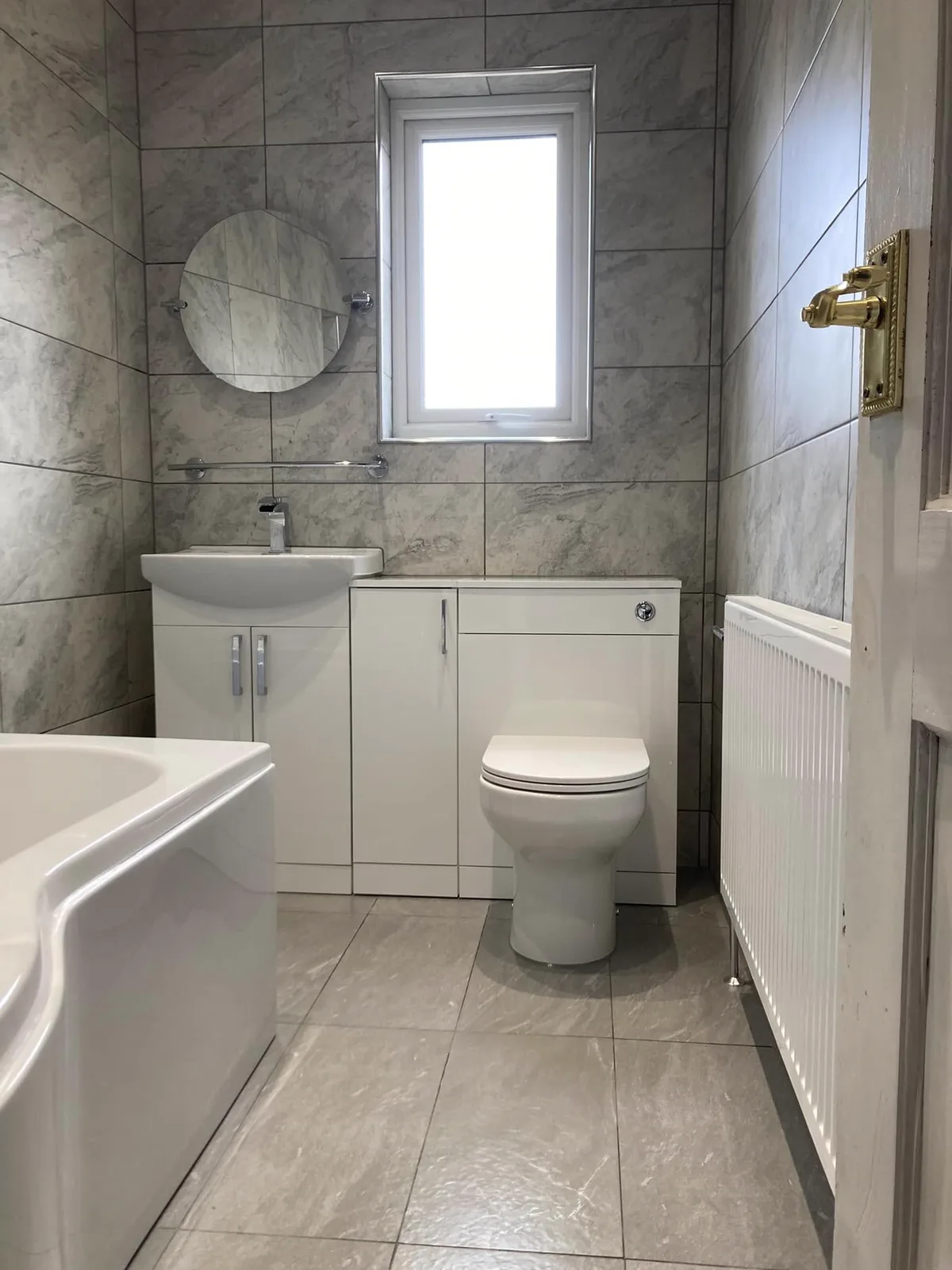 Fresh tiled bathroom with fitted bath and vanity