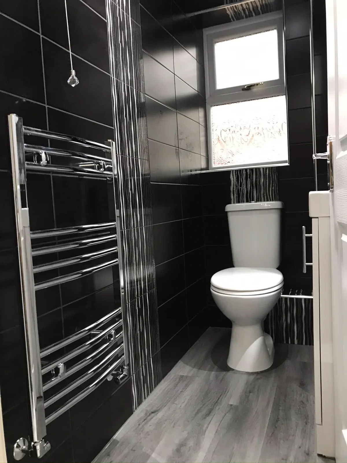 Black tiled bathroom with chrome fittings